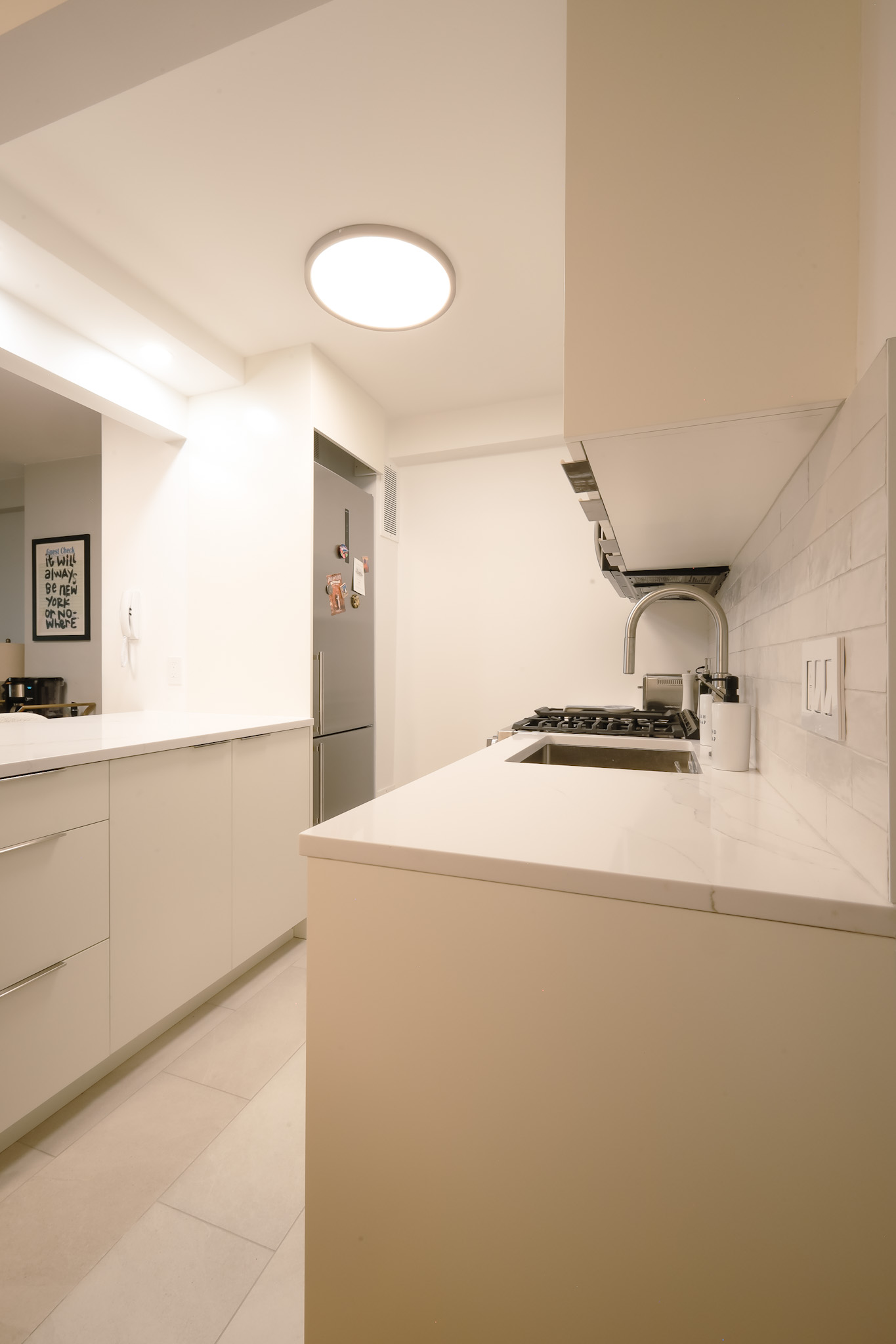 Kitchen — all-white flat-front cabinetry and quartz countertops